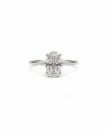 An oval-cut diamond engagement ring with a white gold band, centered on a plain white background.