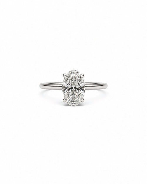 An oval-cut diamond engagement ring with a white gold band, centered on a plain white background.