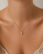 Diamond solitaire pendant worn on model, close-up