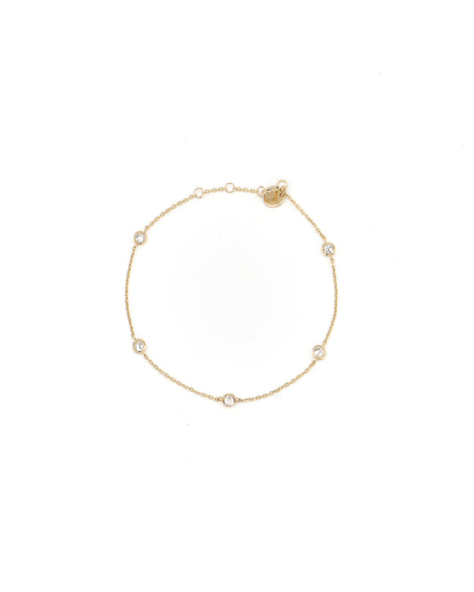 Gold bracelet with small diamonds on a white background