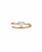 A 14k gold open band ring featuring a small, heart-shaped diamond in the center, set against a plain white background.