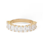 A gold band featuring a series of emerald cut diamonds set closely together.