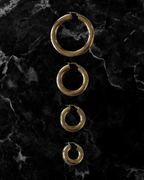 Set of gold hoop earrings on a dark marble surface