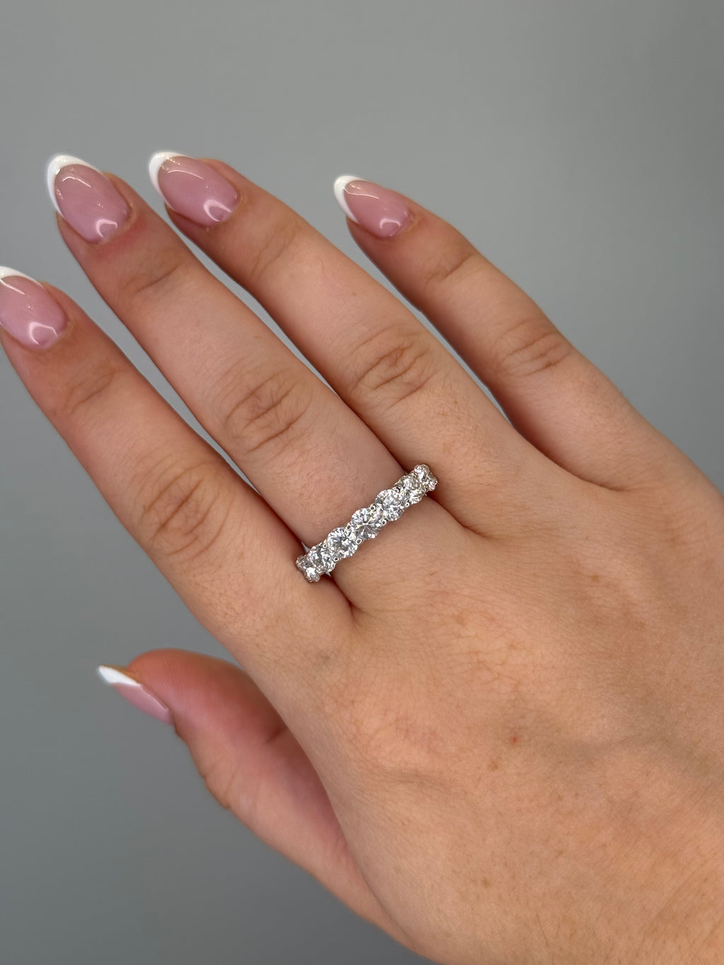 Round diamond half eternity band worn on hand, close-up