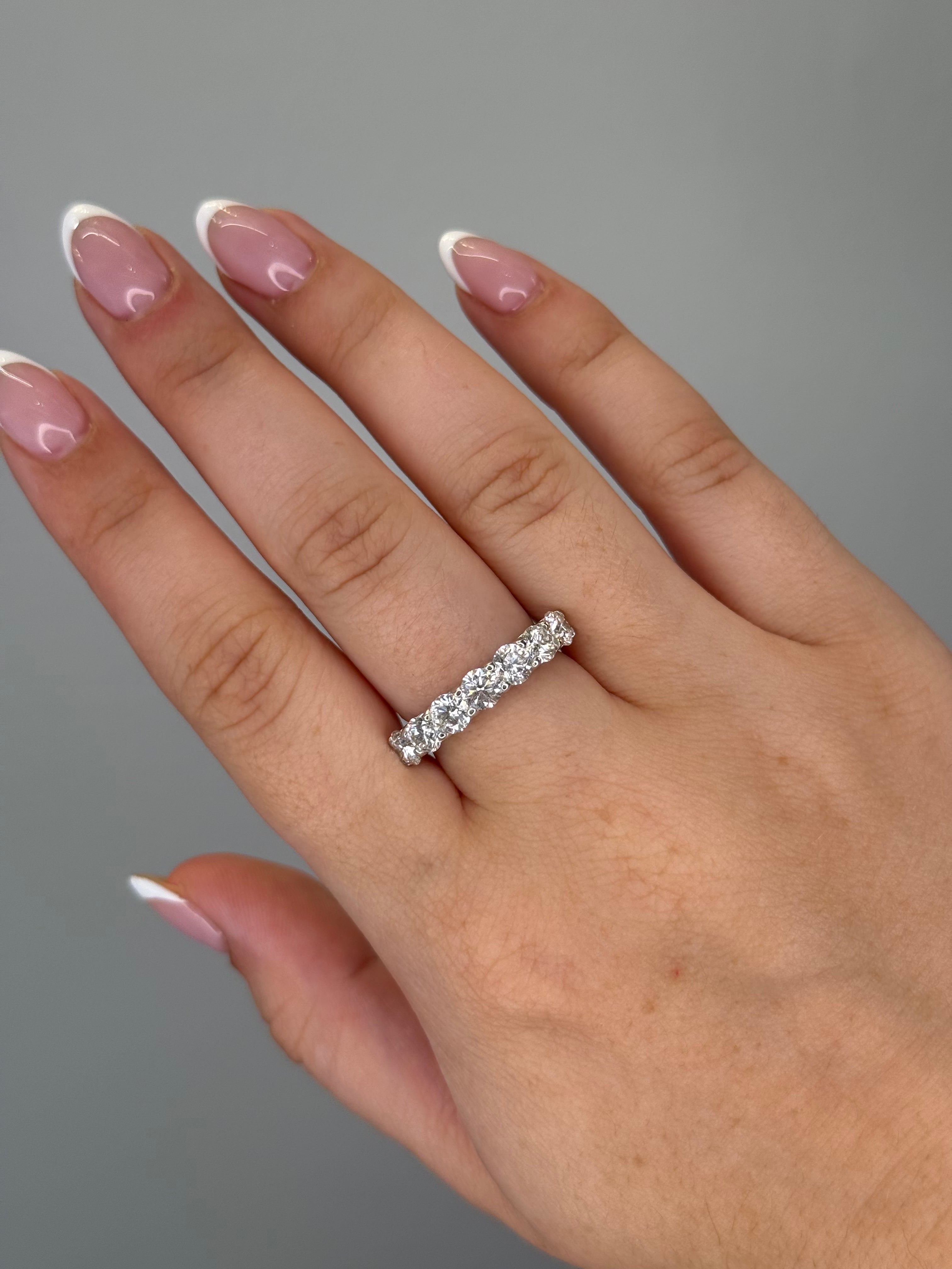 Round diamond half eternity band worn on hand, close-up