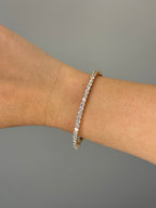 Rose gold diamond bangle worn on wrist, close-up