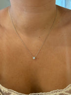 Floating diamond solitaire necklace worn on model, close-up