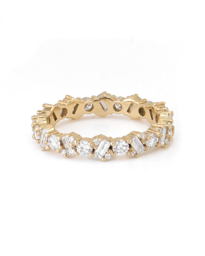 A gold eternity ring with alternating baguette and round-cut diamonds.