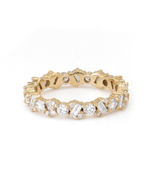 A gold eternity ring with alternating baguette and round-cut diamonds.