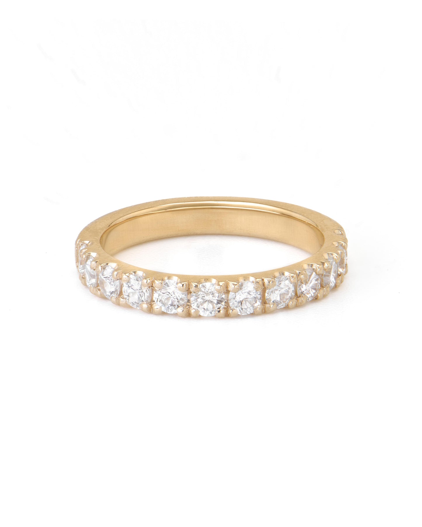 A gold pave diamond ring with multiple diamonds set close together, extending halfway around the band.