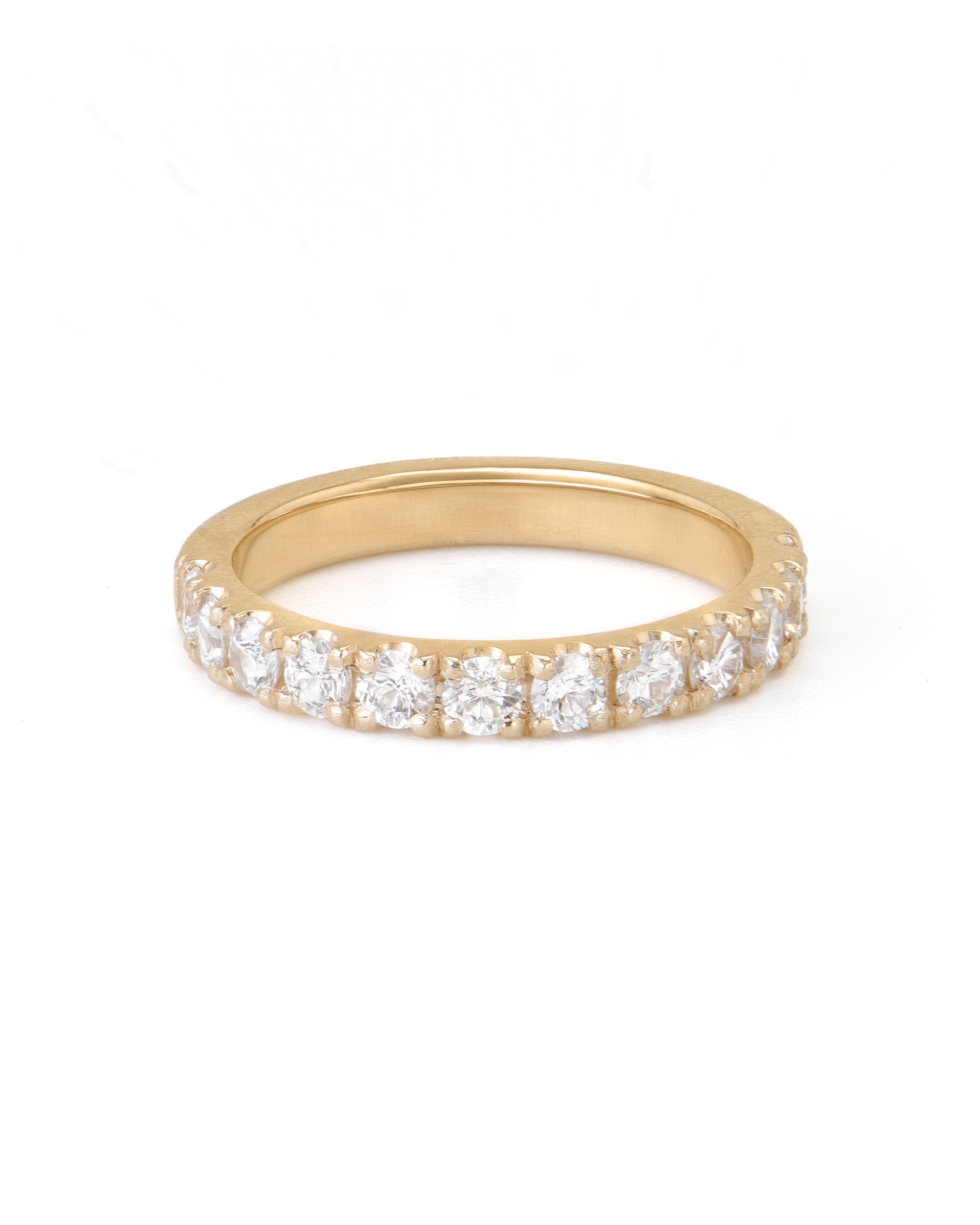 A gold pave diamond ring with multiple diamonds set close together, extending halfway around the band.