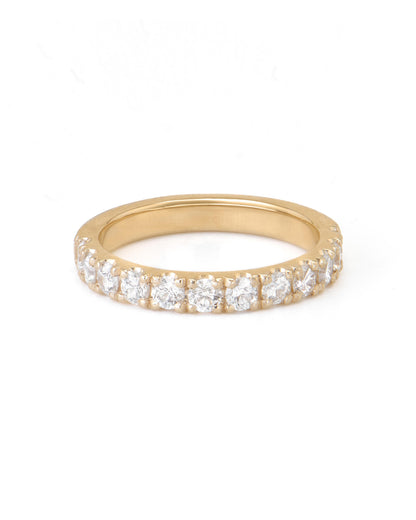 A gold pave diamond ring with multiple diamonds set close together, extending halfway around the band.