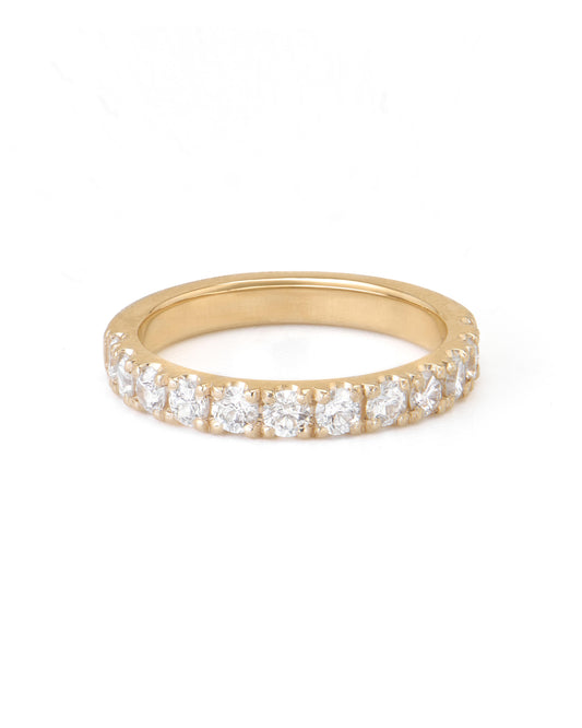 A gold pave diamond ring with multiple diamonds set close together, extending halfway around the band.