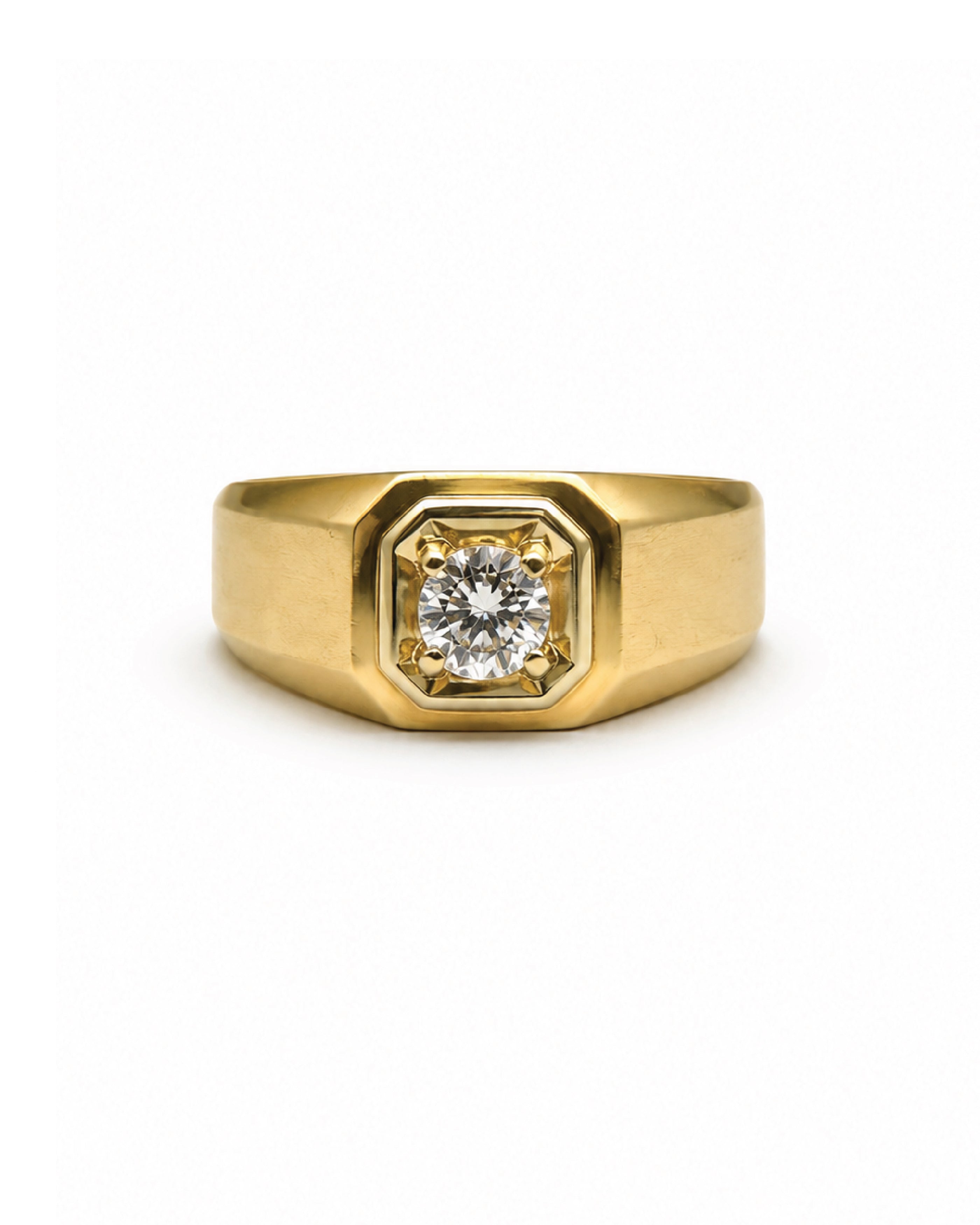 A yellow gold signet ring with a prominent octagonal bezel setting holding a round brilliant-cut diamond, shown against a plain white background.