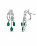 A pair of white gold drop earrings featuring oval-cut emeralds and pavé-set diamonds, shown on a plain white background.