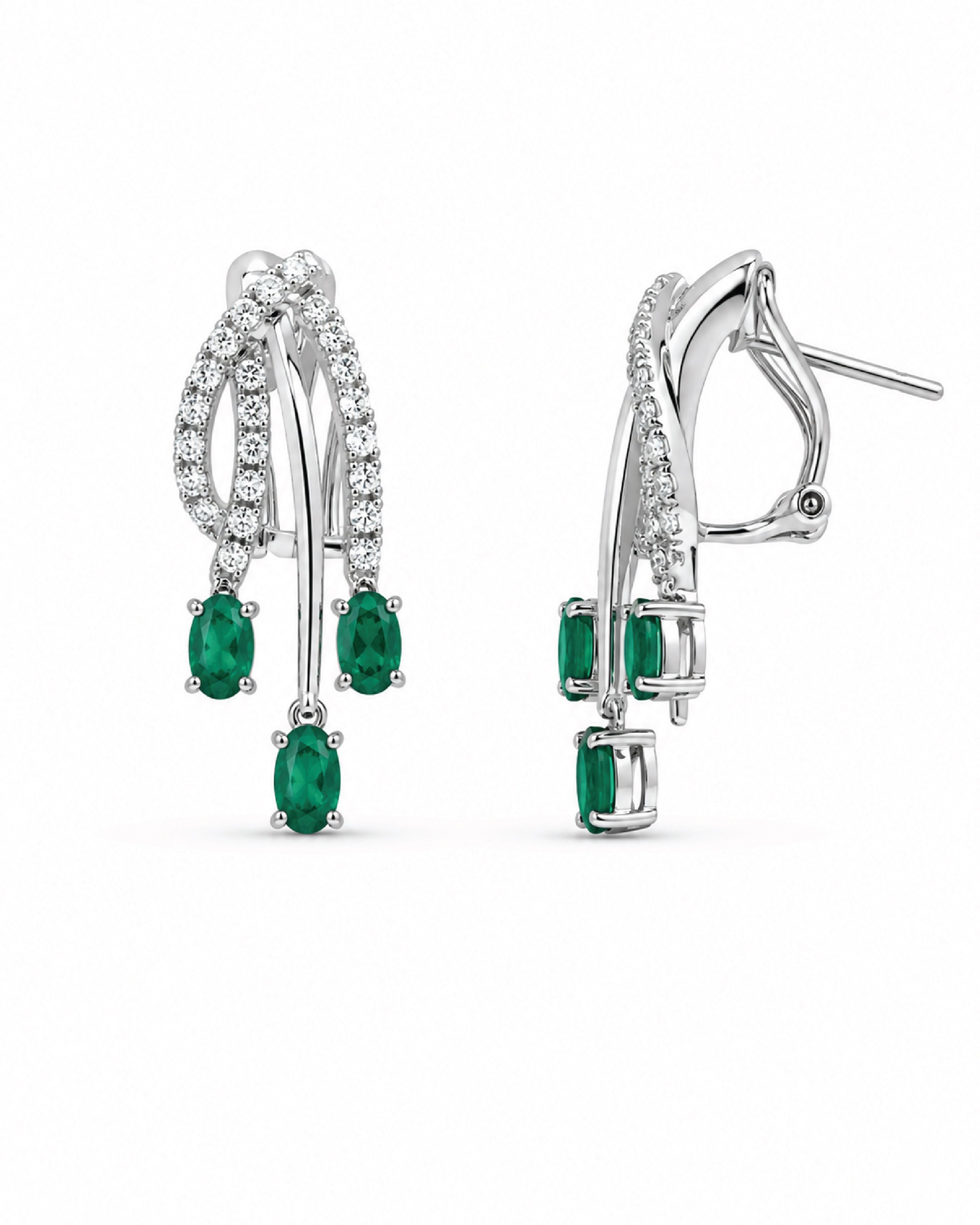 A pair of white gold drop earrings featuring oval-cut emeralds and pavé-set diamonds, shown on a plain white background.