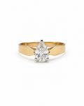 A yellow gold ring featuring a pear-cut diamond in a prong setting, shown against a plain white background.