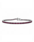 A tennis bracelet featuring round deep red rubies in a white gold setting, displayed on a clean white background.